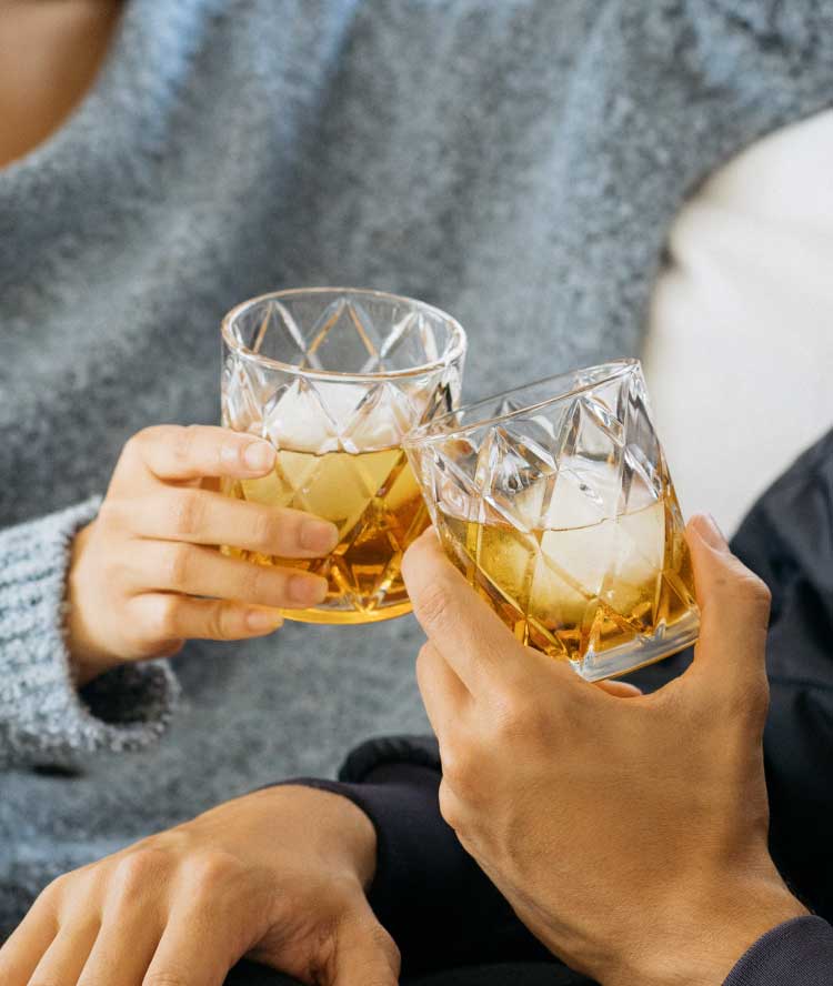 Cheers with two glasses of bourbon