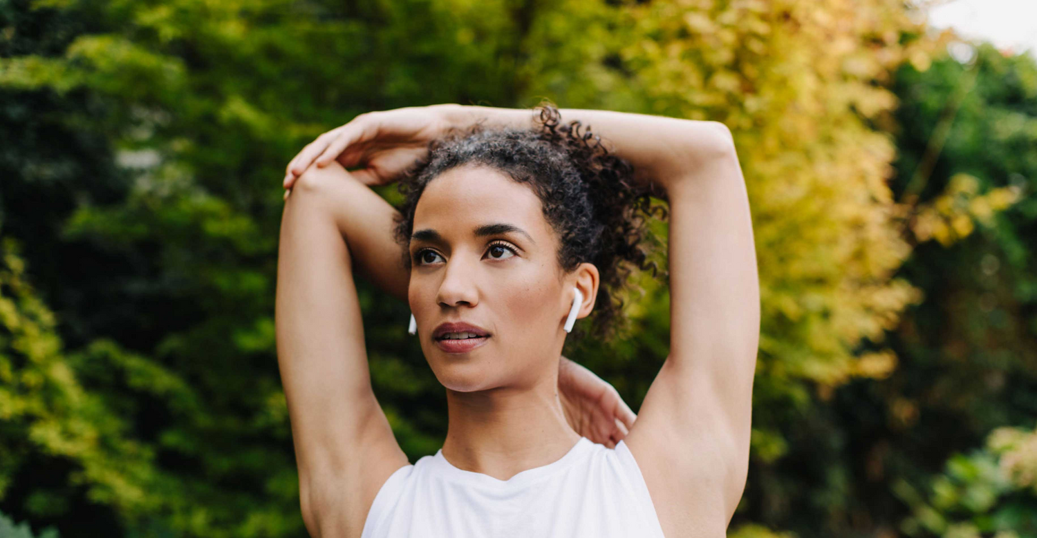 Woman stretching outdoors, embodying the ZBiotics mission of better living through biotechnology